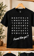 HolyTee's found him yet shirt on wooden hanger in warm neutral studio