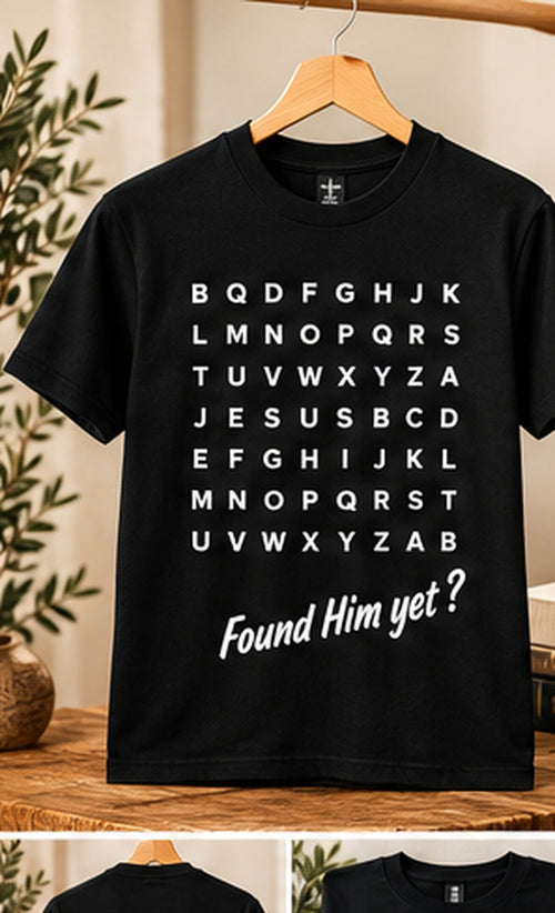HolyTee's found him yet shirt on wooden hanger in warm neutral studio